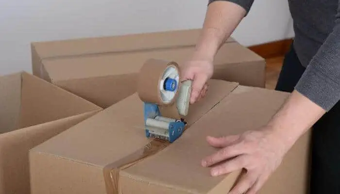applying duct tape to a cardboard box