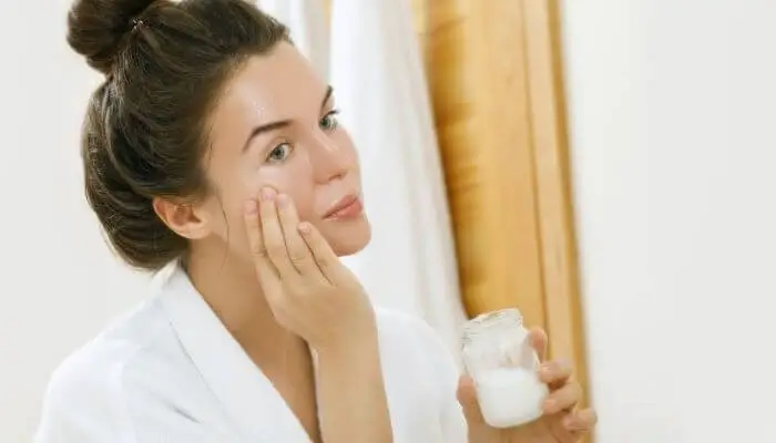 woman applying coconut oil to her face