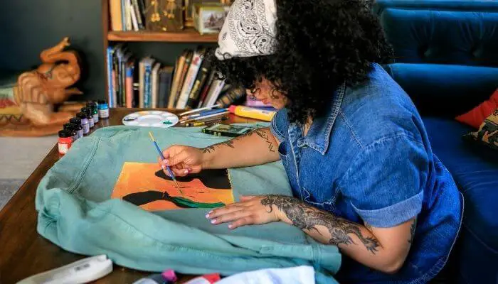 a lady painting a fabric bag