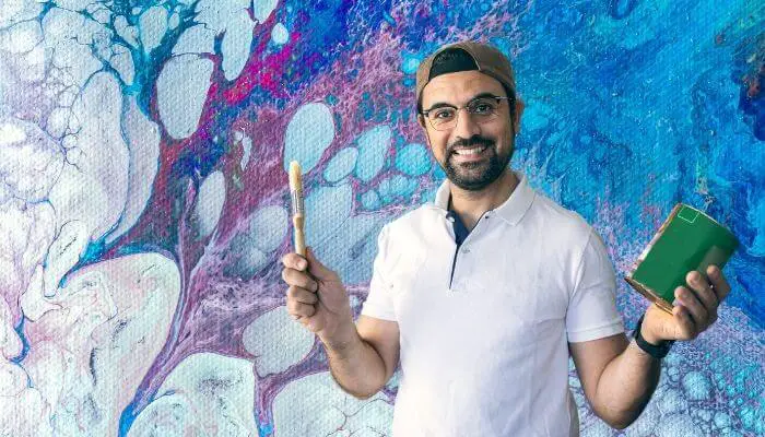 man using varnish to waterproof acrylic painting