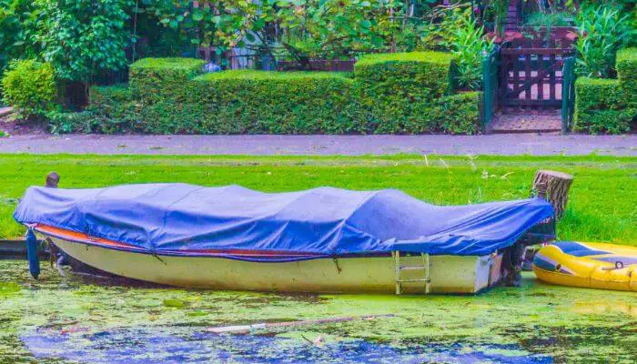 boat covered in blue canvas boat cover